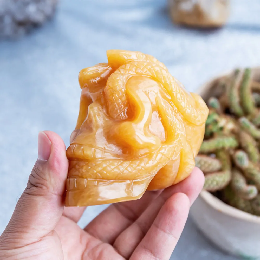 Wholesale natural high quality hand carved orange calcite crystal skulls folk carfts with snake for Halloween decoration