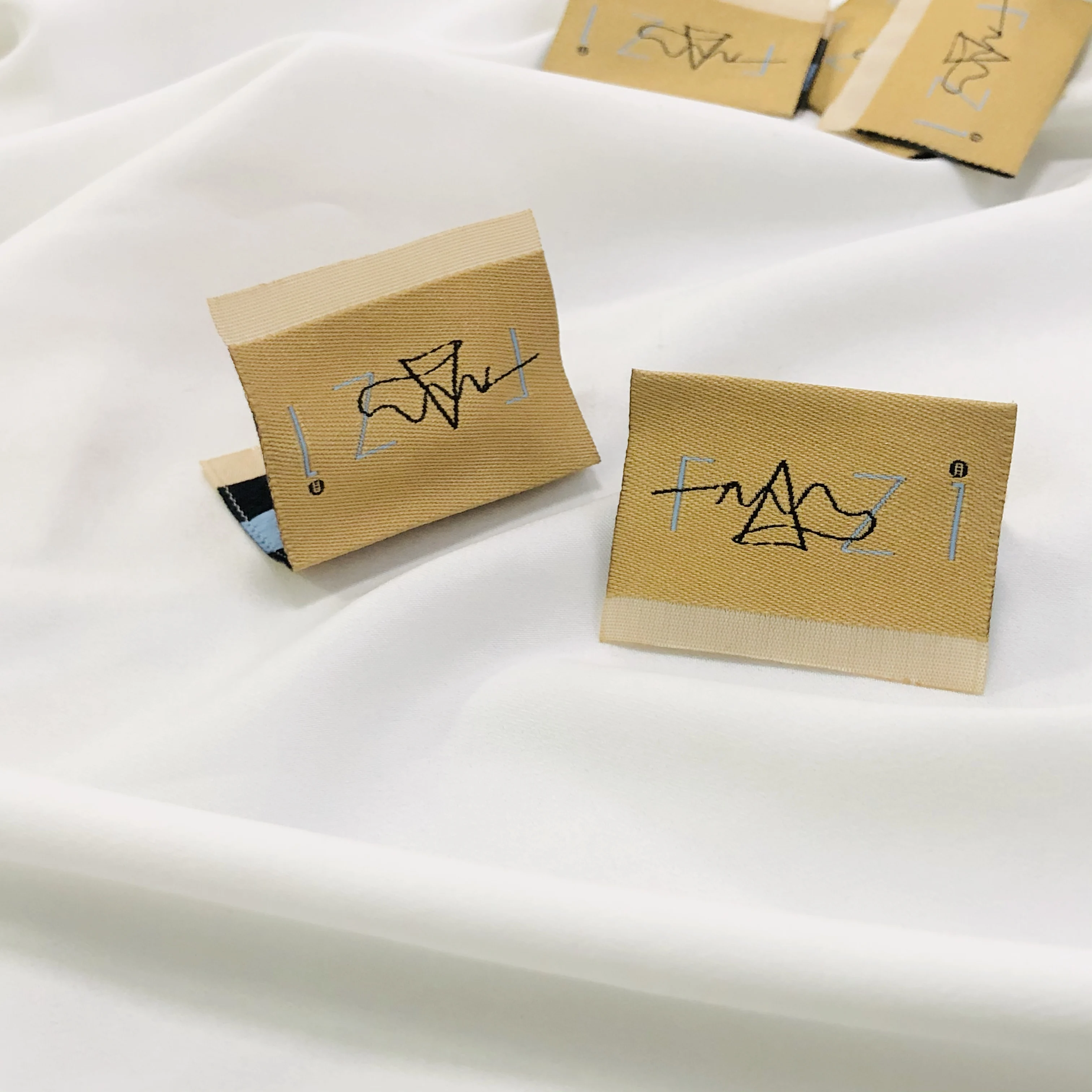 High density fashion design custom logo end fold black label swing on woven care label main tag for clothing socks