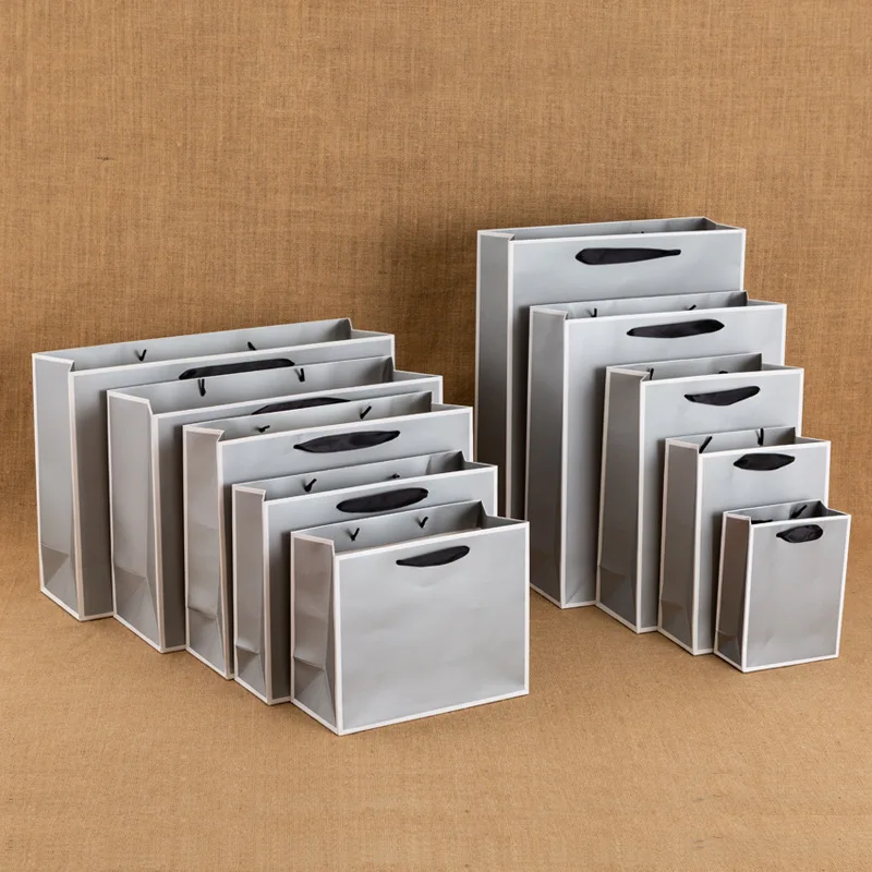 Wholesale custom printed grey and white cardboard stock gift clothing shopping paper bag with your own ribbon handle logo