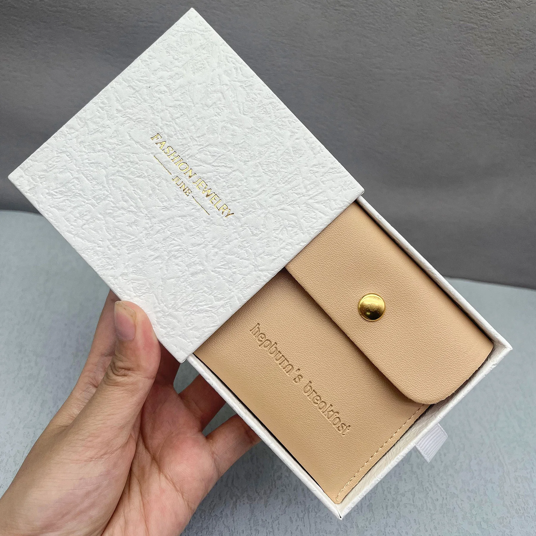 Небольшая сумка и коробка для ювелирных изделий из искусственной кожи с тисненым логотипом, серьга для браслета и демонстрация ювелирных изделий.