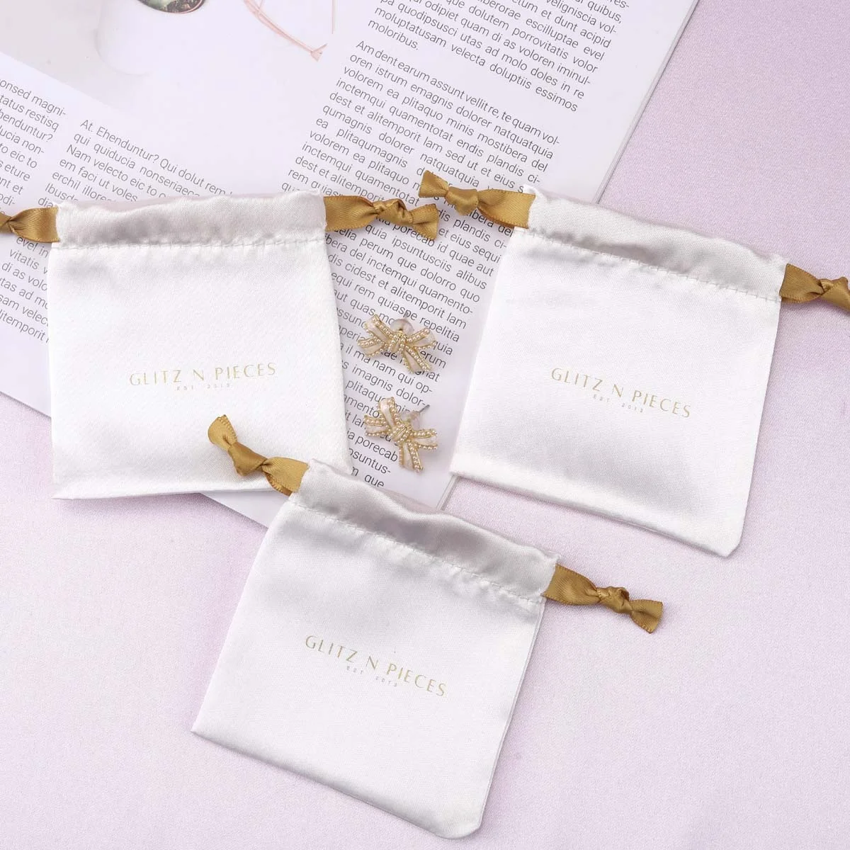 Маленькие атласные ювелирные изделия с принтом логотипа