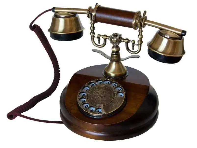 The Old-Fashioned Wall-Mounted Wooden Retro Telephone with Metal Parts with Vintage Rotary Dial and Metal Bell