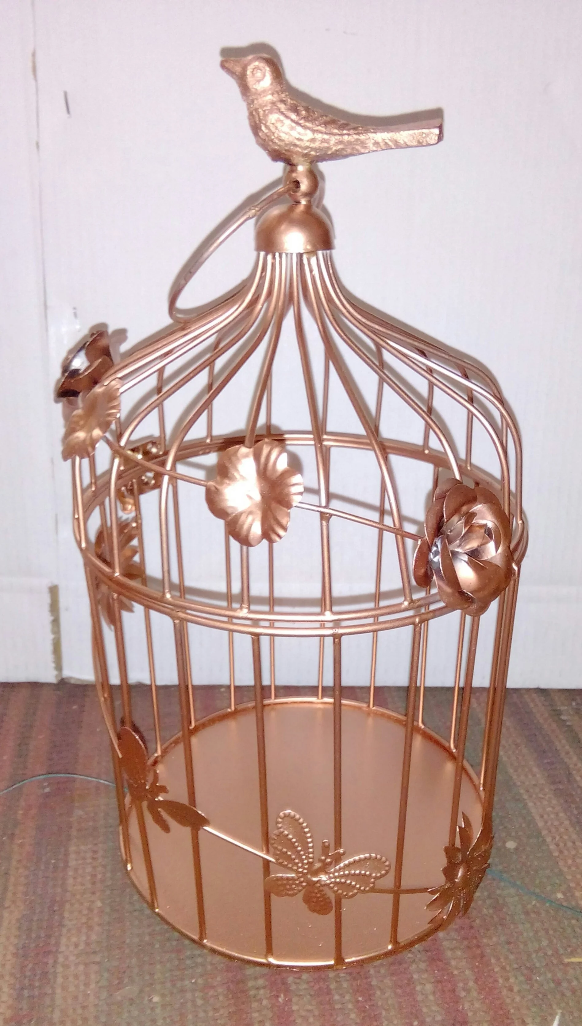 Metal decorative bird cage in rose gold color in bird design .