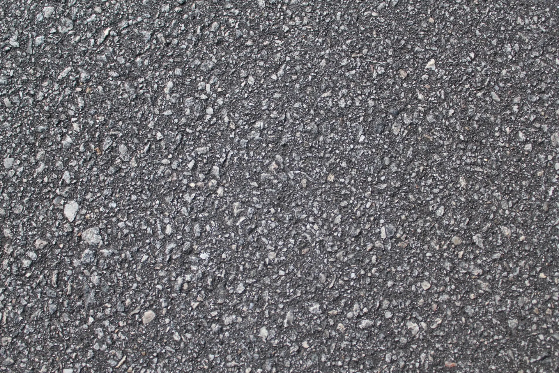  Свежеуложенный черный битумный асфальт с высокой кромкой до гравия показывающей конструкцию