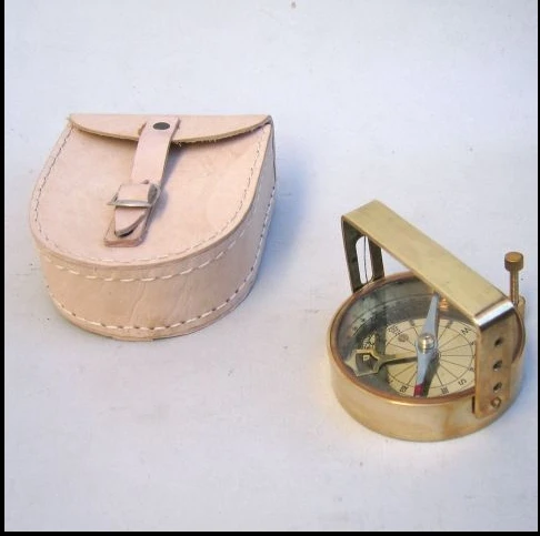 brass compass on wooden box